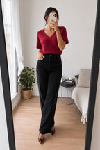 Jean Elise noir porté avec un pull rouge framboise